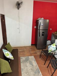 a living room with a refrigerator in a red wall at Buganvilla Quepos No 2 Aire acondicionado in Quepos