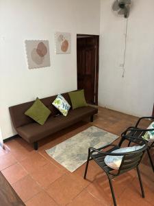 a living room with a couch and a chair at Buganvilla Quepos No 2 Aire acondicionado in Quepos