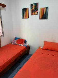 two beds sitting next to each other in a room at Buganvilla No 3 Aire Acondicionado in Quepos
