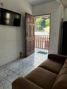 a living room with a couch and a flat screen tv at Buganvilla No 3 Aire Acondicionado in Quepos +5 photos