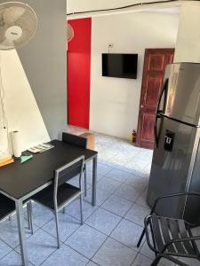 a kitchen with a black table and a refrigerator at Buganvilla No 3 Aire Acondicionado in Quepos