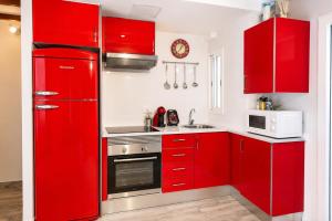 a red kitchen with white appliances and red cabinets at apartamento las torres-botanico con 2 habitaciones in Valencia +28 photos