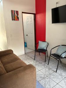 a living room with a couch and two chairs at Buganvilla No 3 Aire Acondicionado in Quepos