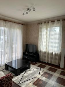 a living room with a tv and a coffee table at L'Authentique Jurassien in Champagnole