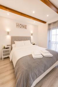 a bedroom with a large bed with a home sign on the wall at apartamento las torres-botanico con 2 habitaciones in Valencia