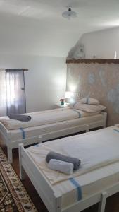 a group of three beds in a room at Facilitati cazare Raluca in Viscri
