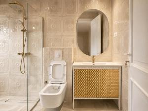 a bathroom with a toilet and a sink and a mirror at Lusso Hotel in Prishtinë