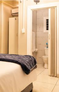 a bedroom with a bed and a bathroom with a toilet at Tiah Whyte, Durban in Durban