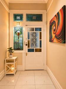 a hallway with a white door and stained glass windows at Tiah Whyte, Durban in Durban