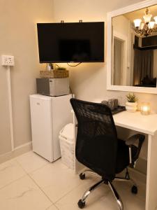 a desk with a black chair in a room at Tiah Whyte, Durban in Durban