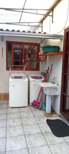 a kitchen with two washing machines and a sink at Quarto suite e sala no Centro in Nova Friburgo