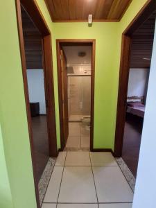 a bathroom with a toilet in a room with green walls at Quarto suite e sala no Centro in Nova Friburgo