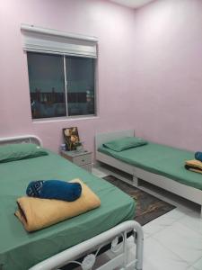 a hospital room with two beds and a window at Ammaiti Homestay Kulim in Kulim
