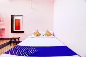 a bedroom with a bed with a blue and white blanket at Hotel O NANDINI in Dibrugarh