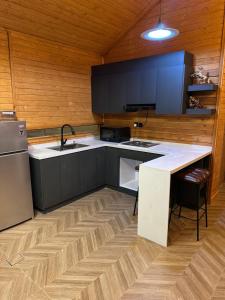 a kitchen with a sink and a refrigerator at اكواخ سمر in Abha