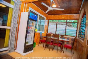 a restaurant with a table and chairs and a refrigerator at Le Mia KD lodge in Sekondi-Takoradi