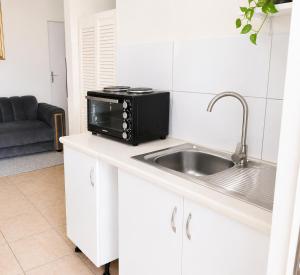 a kitchen with a sink and a microwave at Tiah Grey, Durban in Durban