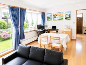 a living room with a couch and a table at Moio Homestay in Sapporo