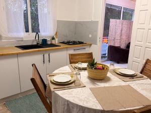 a kitchen with a table with a bowl of fruit on it at Sunshine Privilège in Deshaies