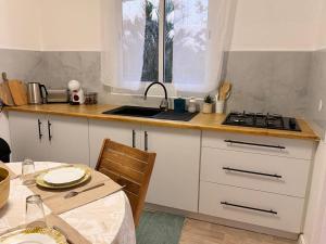a kitchen with a sink and a stove and a table at Sunshine Privilège in Deshaies
