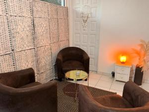 a living room with two chairs and a table at Sunshine Privilège in Deshaies +42 photos