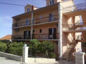 un edificio de apartamentos con escaleras y balcones. en Rooms & Studio, en Supetar