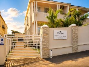 a building with a white staircase in front of it at Tiah Grey, Durban in Durban
