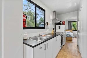 a white kitchen with a sink and a window at Bertha's at Long Beach in Long Beach