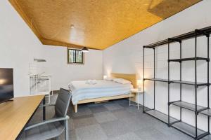 a bedroom with a bed and a desk and shelves at Bertha's at Long Beach in Long Beach