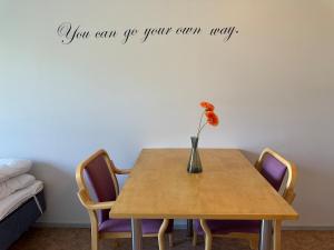 a dining room table with a vase with a flower on it at Private apartment in Kokkola +7 photos