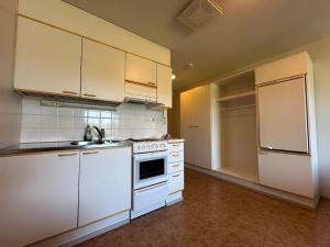 a kitchen with white cabinets and a white stove top oven at Private apartment in Kokkola