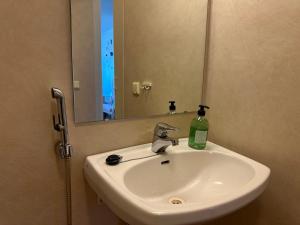 a bathroom sink with a mirror and a bottle of soap at Private apartment in Kokkola