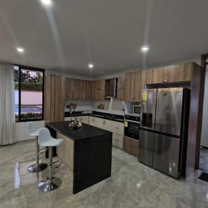 a kitchen with a stainless steel refrigerator and a counter at Villa Conejo Miraflores in Chinauta