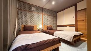 a bedroom with two beds and a cabinet at 永山邸 in Asahikawa