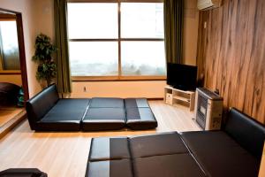 a living room with a couch and a tv at 永山邸 in Asahikawa