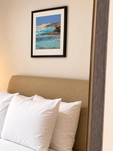 a framed picture above a bed with white pillows at Pier Hotel Port Lincoln in Port Lincoln +4 photos