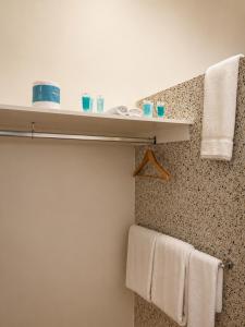 a bathroom with a sink and towels on a wall at Pier Hotel Port Lincoln in Port Lincoln