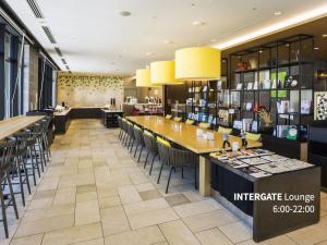 a restaurant with a bar with chairs and tables at Hotel Intergate Hiroshima in Hiroshima
