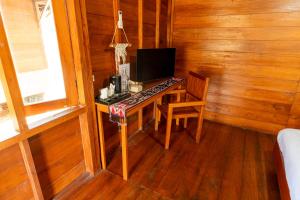 a desk with a computer in a wooden room at Welly Bungalow in Gili Trawangan
