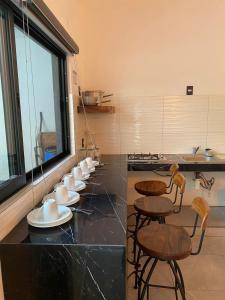 a kitchen with a row of stools and tables at Hotel Boutique Manta in Los Ayala