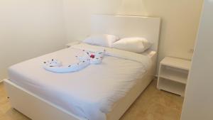 a white bed with two stuffed cats on it at sunrise house in Luxor