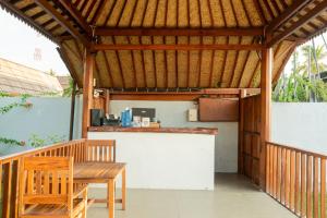 an outdoor kitchen with a table and a bar at Westwood Bungalow in Gili Trawangan