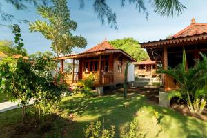 a house with a garden in front of it at Westwood Bungalow in Gili Trawangan