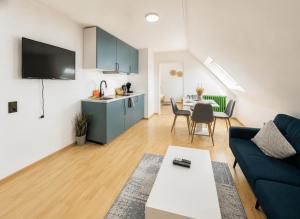 a living room with a blue couch and a table at Fewo ONE - by Europapark in Rust