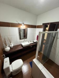a bathroom with a toilet and a sink and a mirror at Pousada Vertente das Águas in Lumiar +87 photos