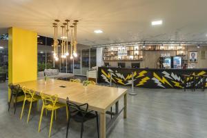 a dining room with a table and yellow chairs at Hotel Cassino Tower Piracicaba by Nacional Inn in Piracicaba