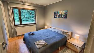 a bedroom with a blue bed and a window at Ventum Village in Punkaharju