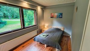 a bedroom with a bed and a large window at Ventum Village in Punkaharju