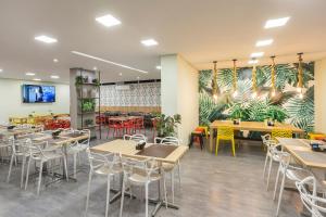 a restaurant with tables and chairs and a mural at Hotel Cassino Tower Piracicaba by Nacional Inn in Piracicaba