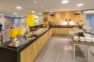 a buffet line in a restaurant with food at Hotel Cassino Tower Piracicaba by Nacional Inn in Piracicaba